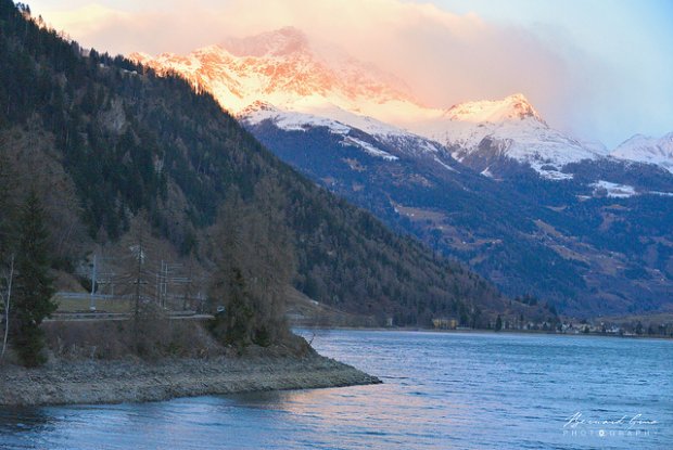 Miralago: le train longe le lac de Poschiavo (965m) encore dans l’ombre alors que les sommets sont atteints par les rayons du soleil – 08:09  Bernard Grua